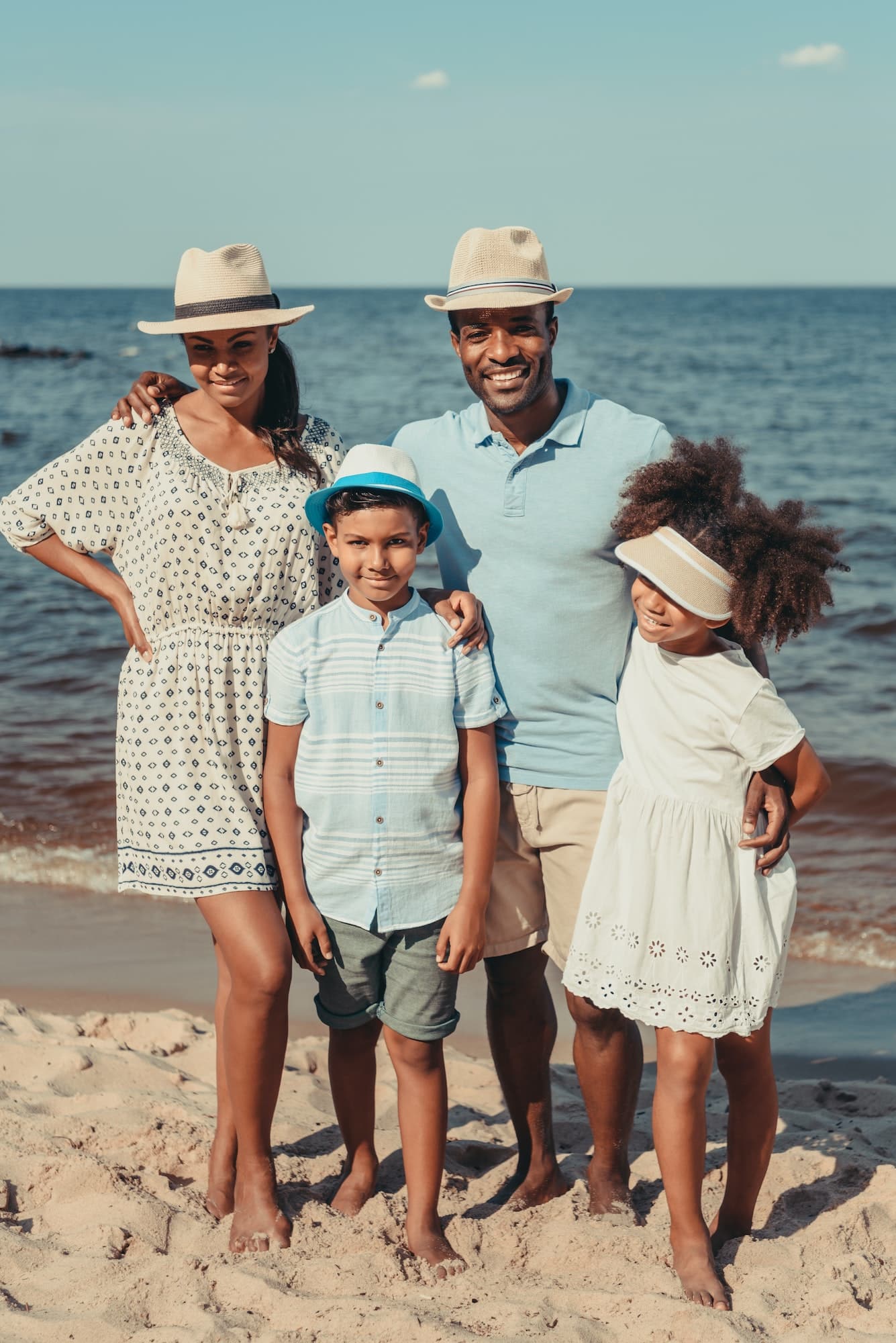 happy african american family standing together and smiling at camera at seaside